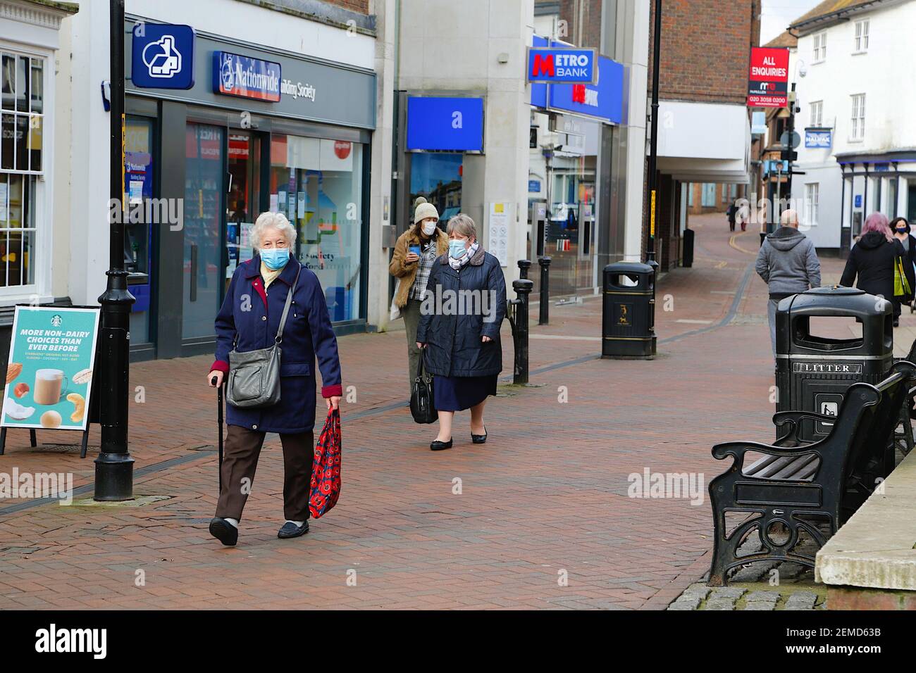 Ashford, Kent, UK. 25 February, 2021. Weekly cases of the coronavirus have come down considerably in Ashford with 71.5 cases per 100,000 population. People wearing face masks during lockdown 3 in the town centre high street. Photo Credit: Paul Lawrenson/Alamy Live News Stock Photo