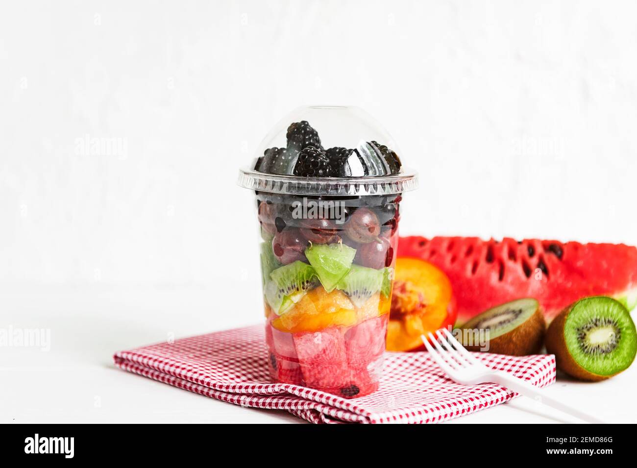 Delicious fruit salad in plastic cup on white background Stock Photo - Alamy