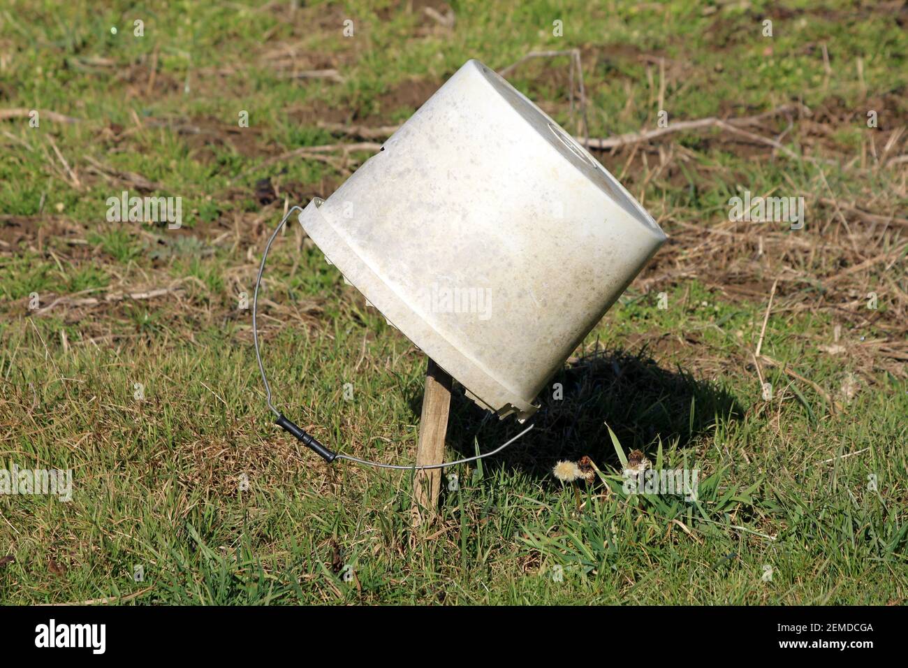 Dirty white cracked broken old plastic bucket with hole on side and ...