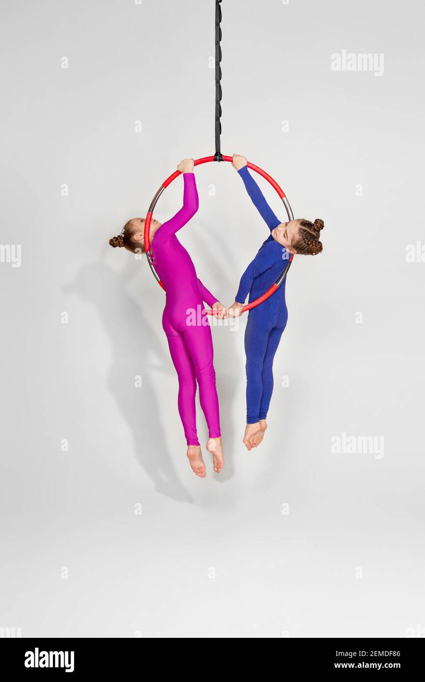 two little child girls shows an acrobatic performance on an aerial hoop. aerial acrobat Stock Photo