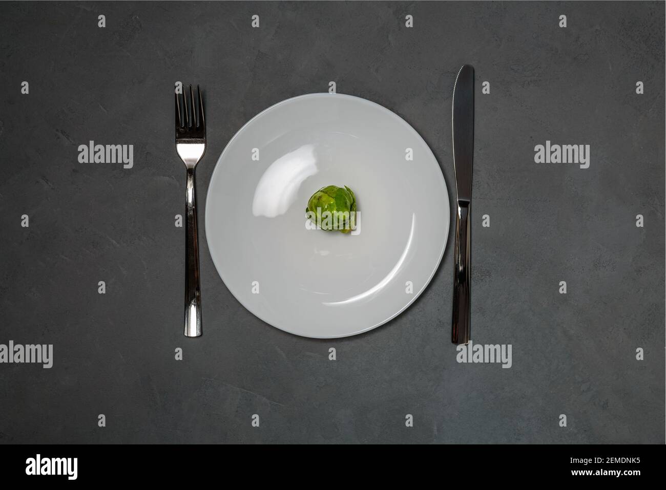Plate with Brussels sprout, fork and knife. Dieting concept, weight loss Stock Photo