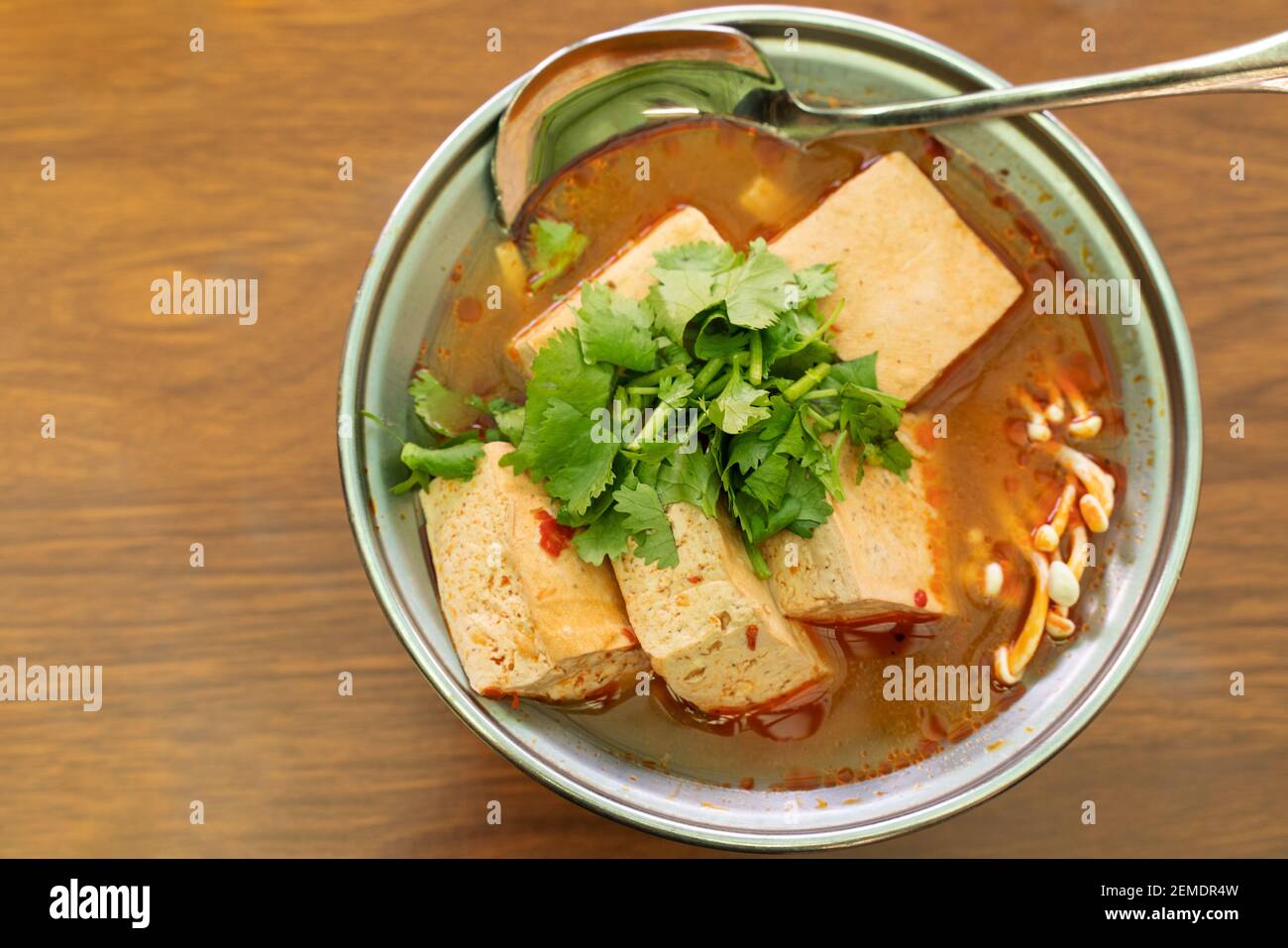 Eating stinky tofu hot pot with spicy soup using spoon, traditional