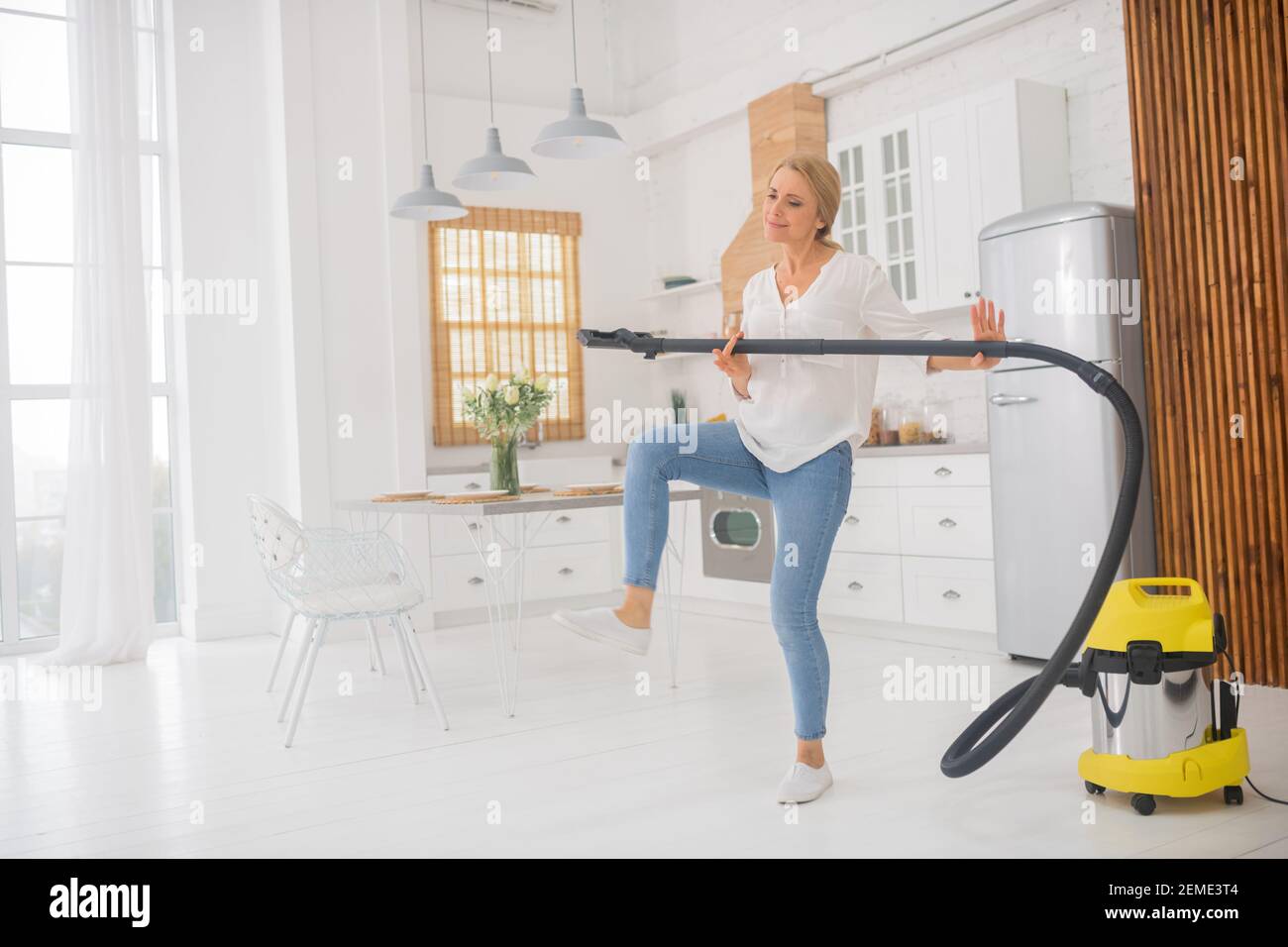 Woman raising her leg with vacuum cleaner tube Stock Photo - Alamy