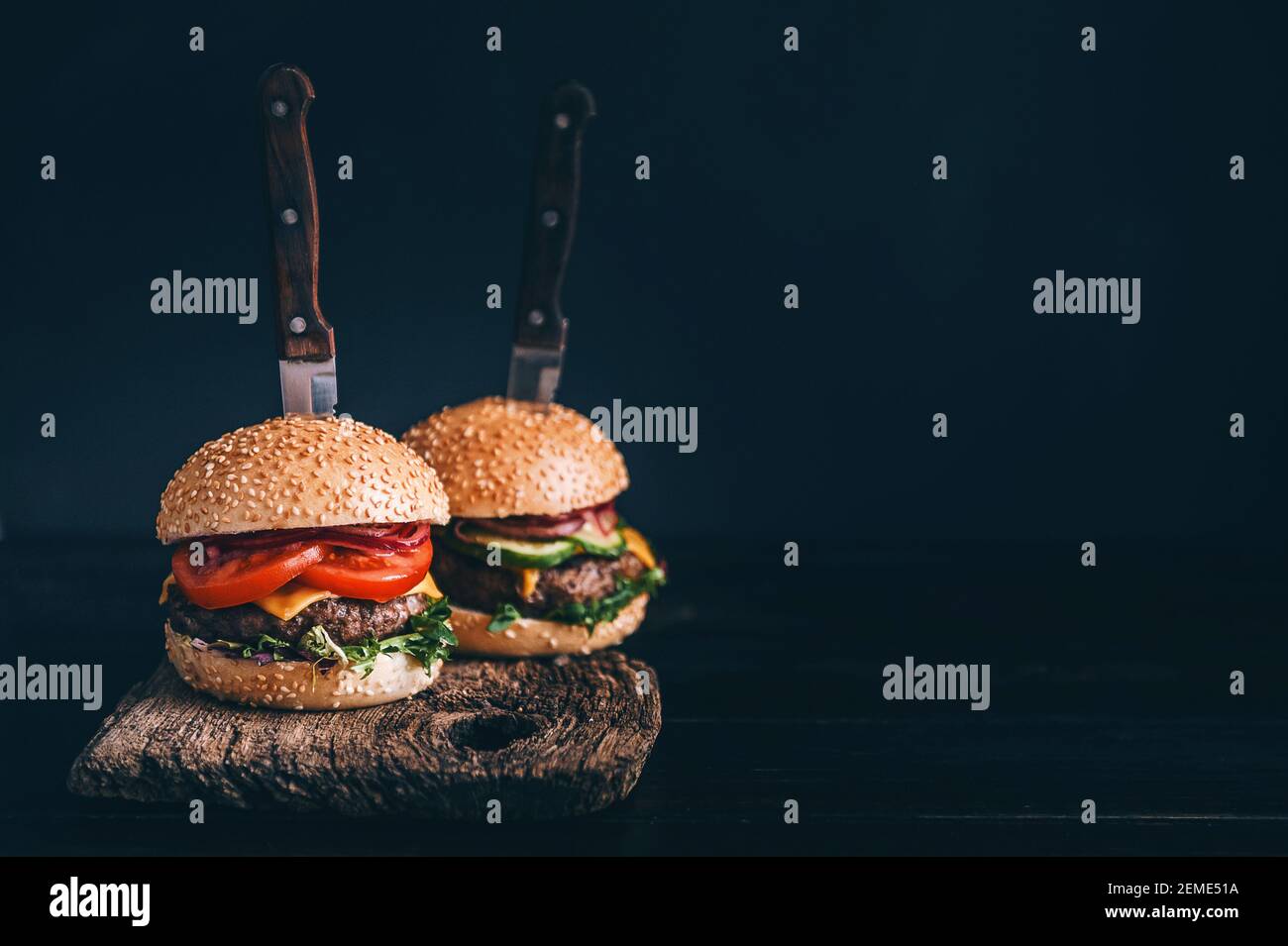 Two mouthwatering, delicious homemade burger used to chop beef. on the wooden table. The