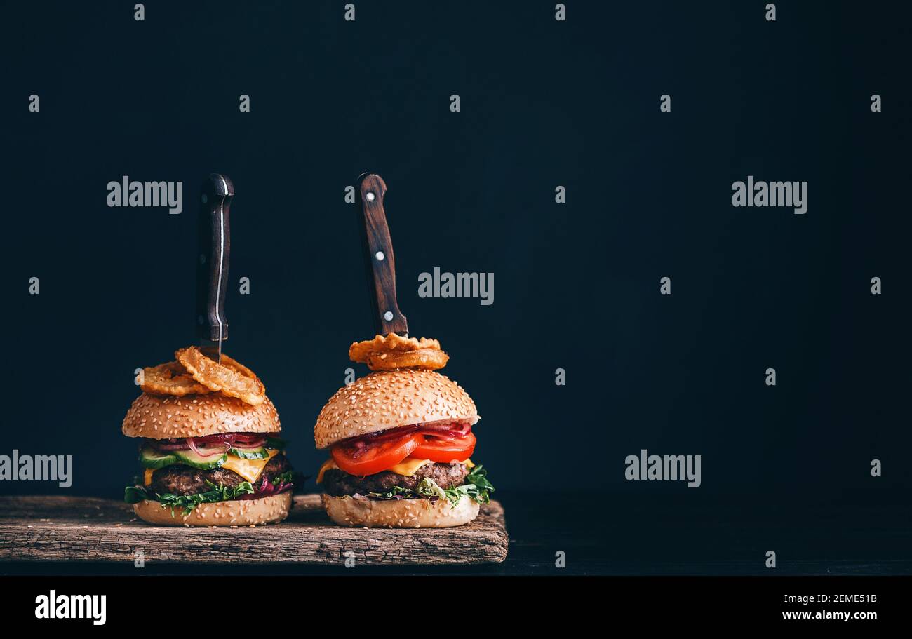 Two mouthwatering, delicious homemade burger used to chop beef. on the wooden table. The
