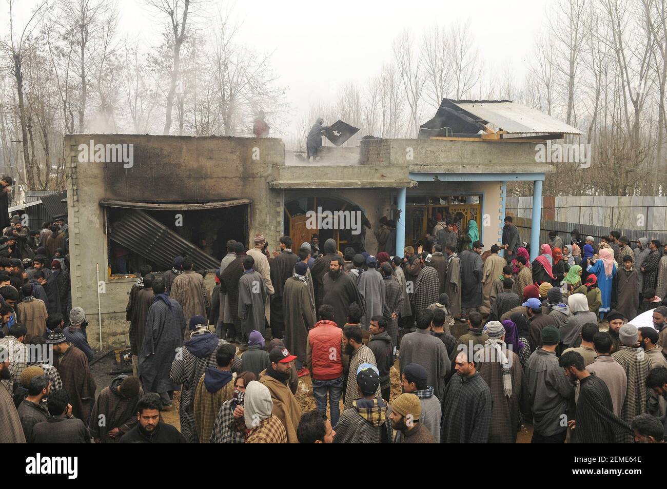 SRINAGAR, INDIA – FEBRUARY 12: People gather near a house that was damaged during a gunfight between militants and security forces at the Ratnipora area of south Kashmir's Pulwama district, some 30 kilometers south of Srinagar, on February 12, 2019 in Jammu and Kashmir, India. (Photo by Waseem Andrabi/ Hindustan Times/Sipa USA) Stock Photo
