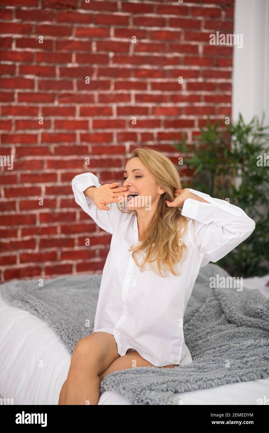 Woman with closed eyes sitting waking up Stock Photo