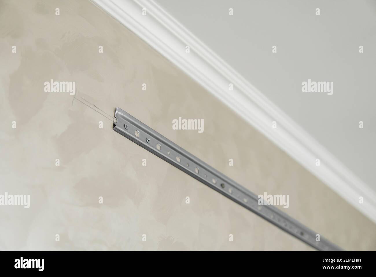 Close-up of stainless steel mounting rail for mounting kitchen cabinets on a wall. Stock Photo