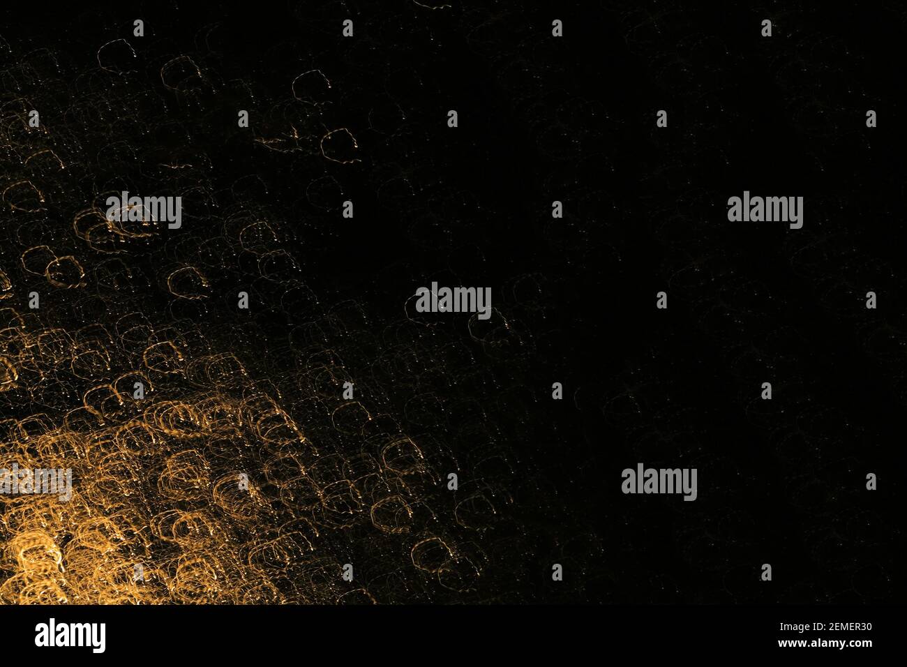 Black surface with circle shaped gold textures of light with long shutter speed at night; color photo, No.1. Stock Photo