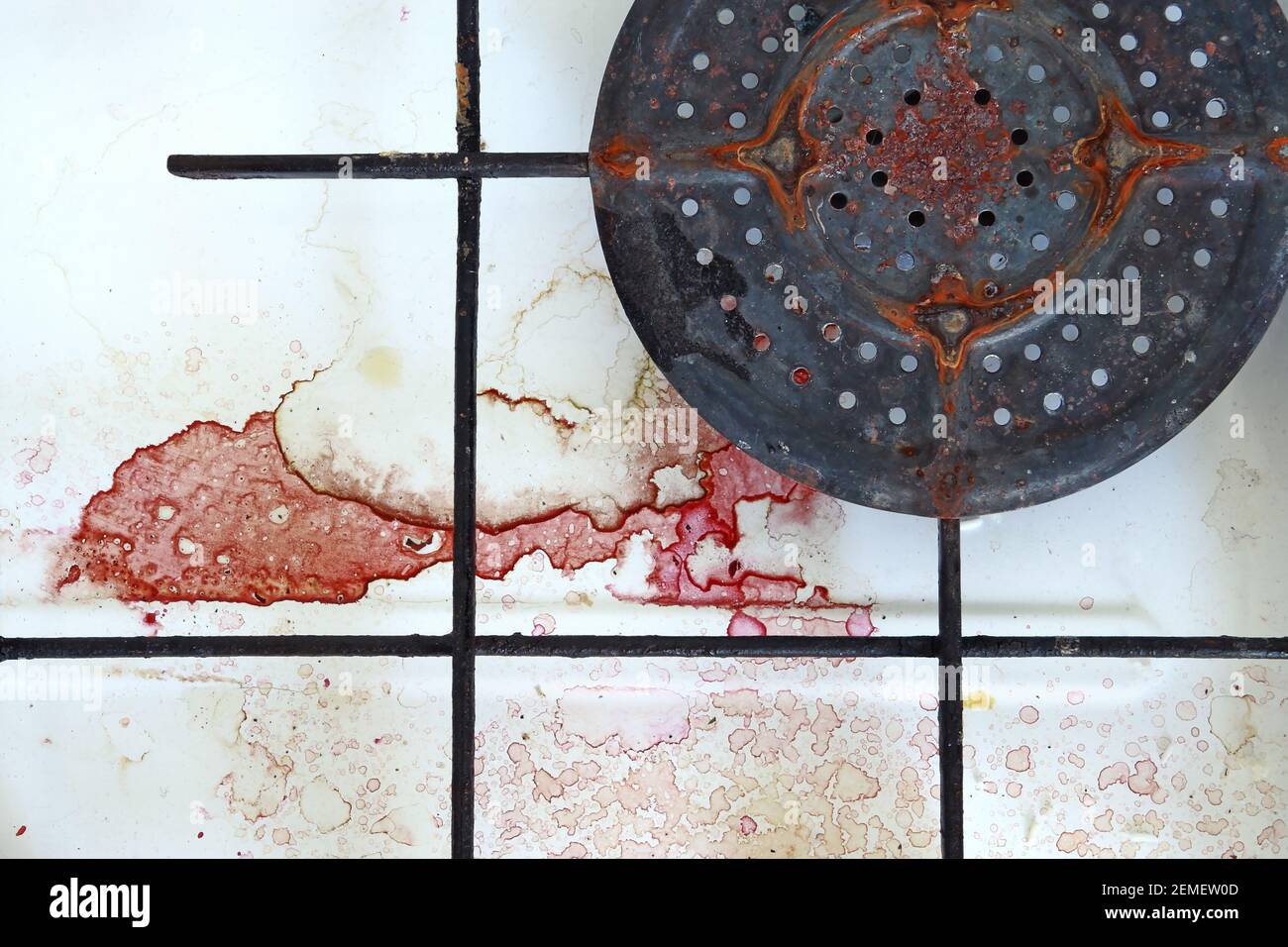 Old, rusty, stained stove with difficult to remove red spots after cooking beetroot; color photo