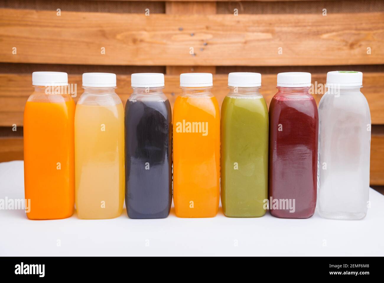Many detox juice bottles on table over wooden background Stock Photo