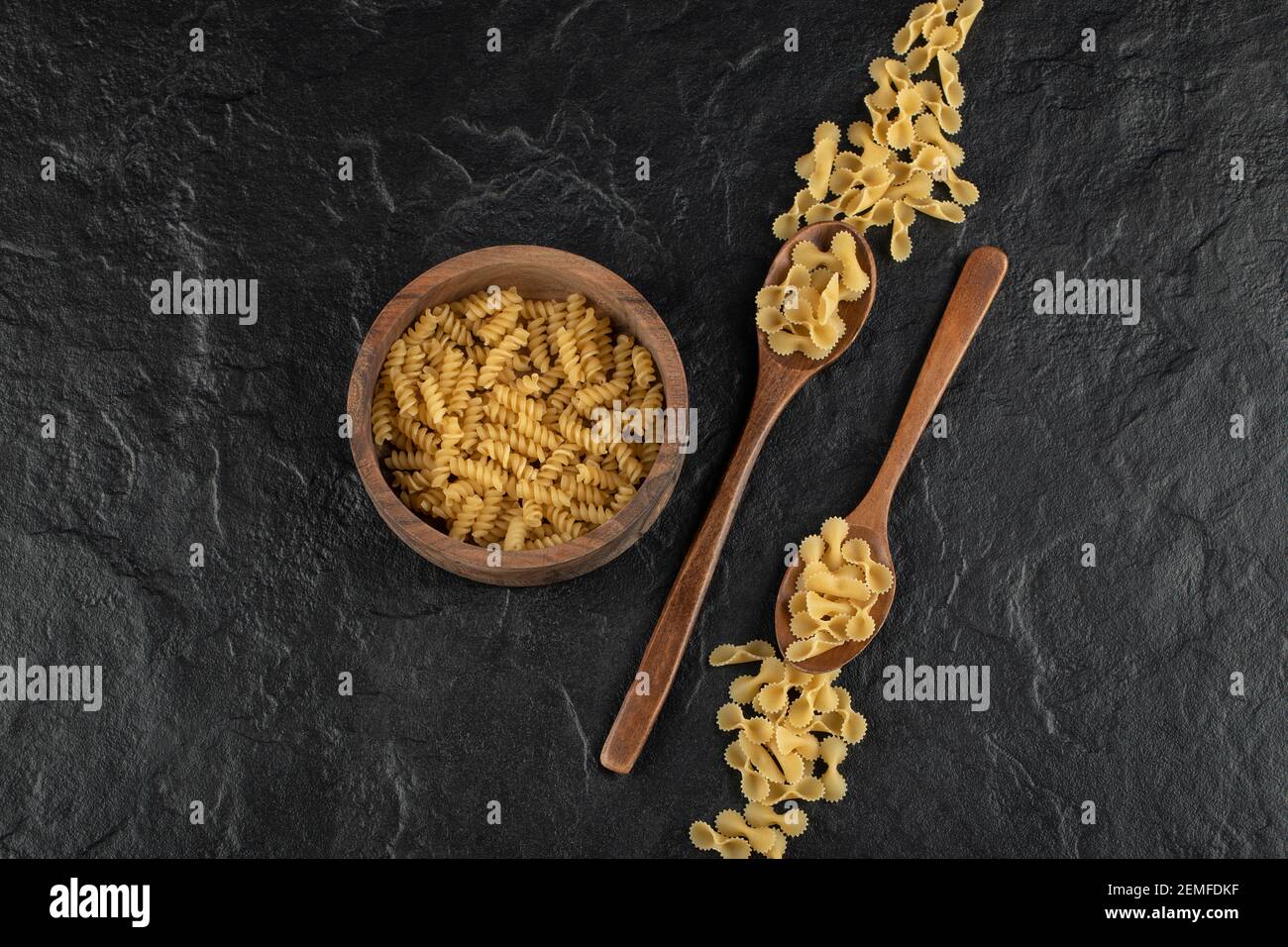 A wooden bowl full of raw girandole pasta Stock Photo