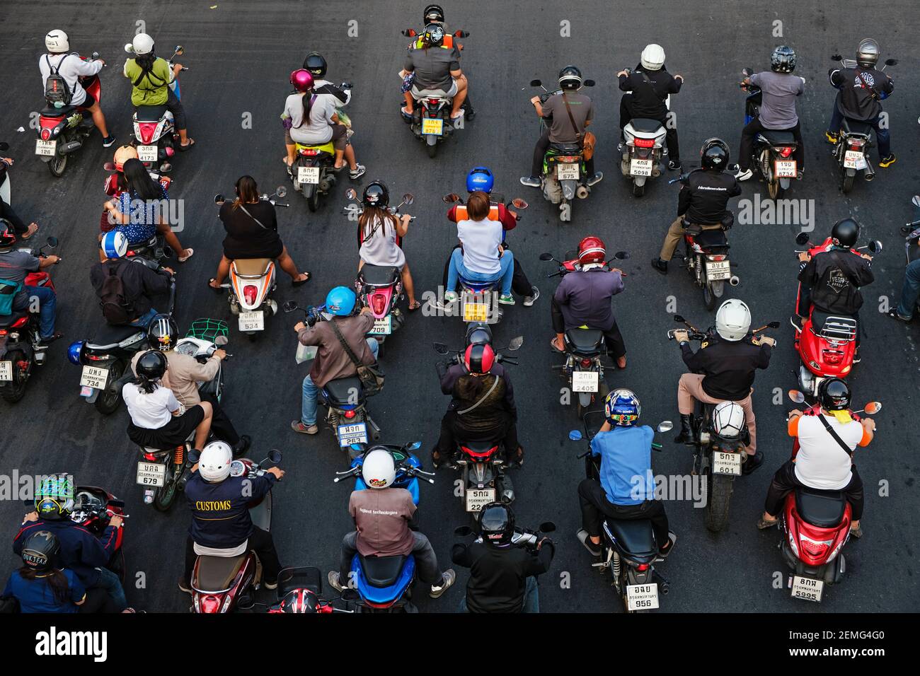 Motorbikes waiting for green light at a busy road intersection in Khlong Toei area of Bangkok, Thailand. Stock Photo