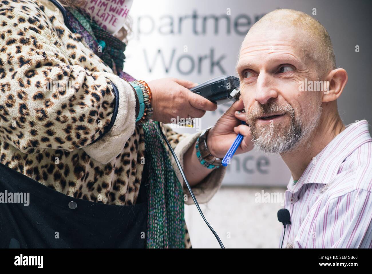 London, UK 25th February, 2021 Anti HS2 protestor and Euston tunneller Dr Larch Maxey shaves hair at HSE offices. he is protesting about the risks being taken with both the lives of the remaining tunnellers by HS2 and with all our futures by the governments failure to stop the climate and nature emergency. Dr Maxey said 'I've never shaved my head before and would not choose to lose my hair, but I am terrified of the close shaves keep seeing during this eviction. Credit: Denise Laura Baker/Alamy Live News Stock Photo