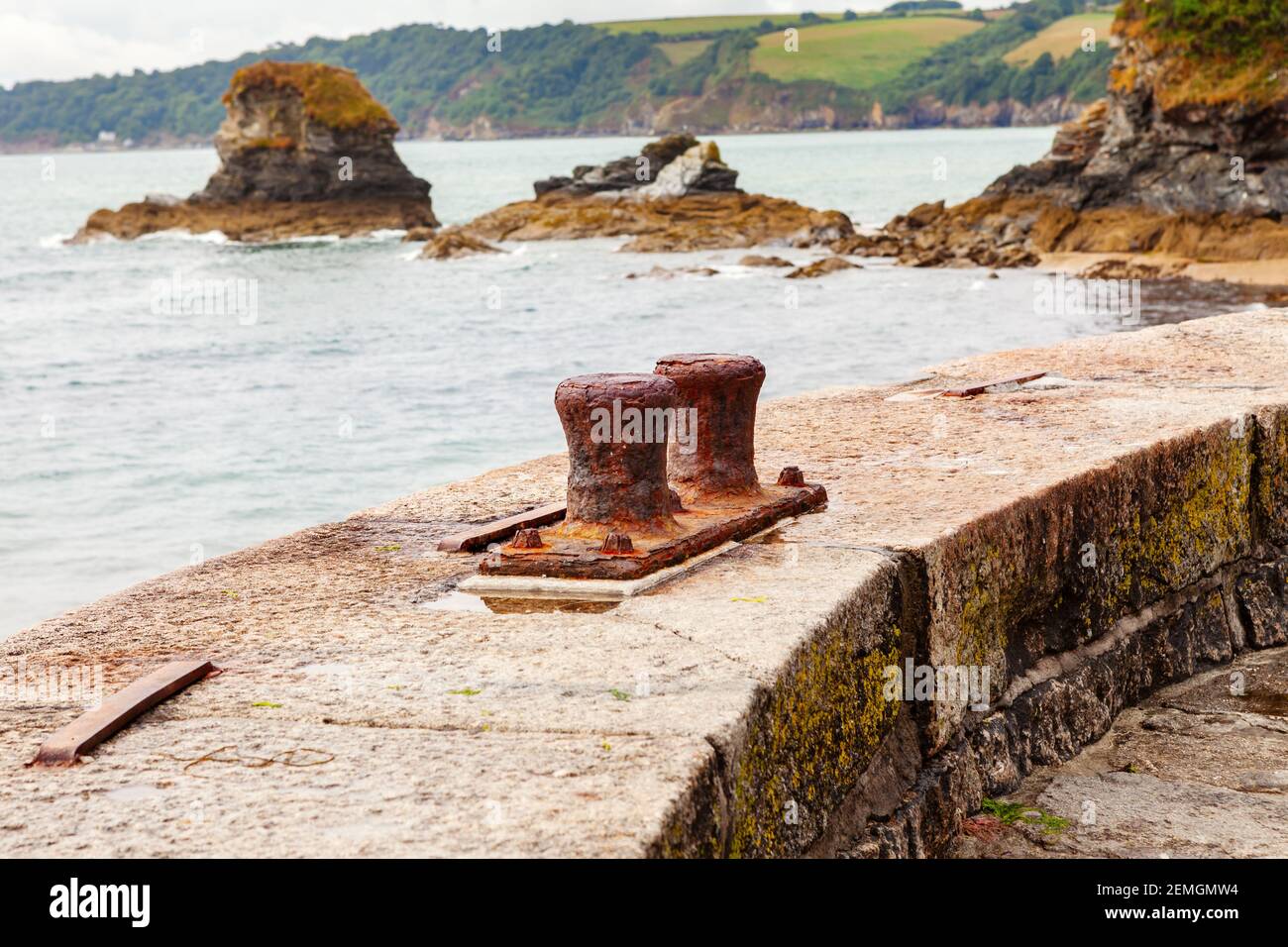 Old Rusty mooring bollards used to anchor boats at Charlestown Harbour, Cornwall Stock Photo