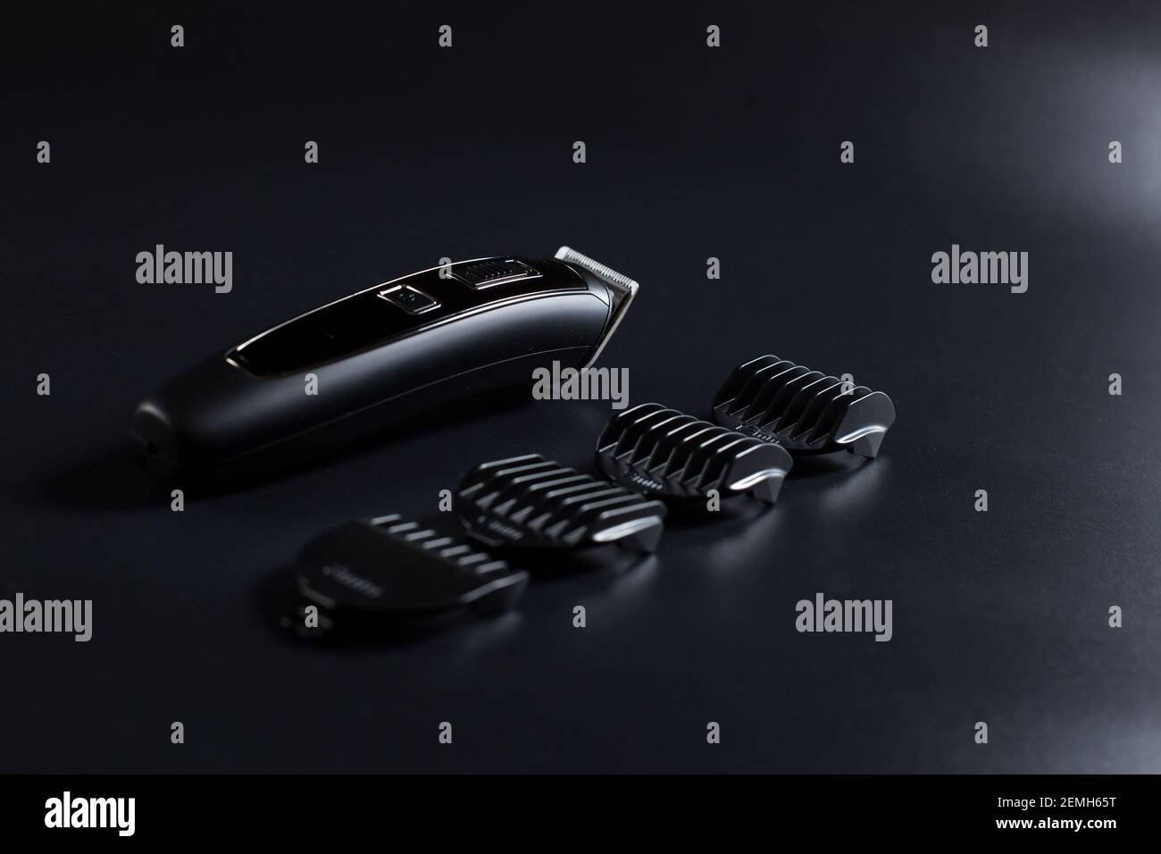 Shaving machine for barber with attachments on black background. Stock Photo