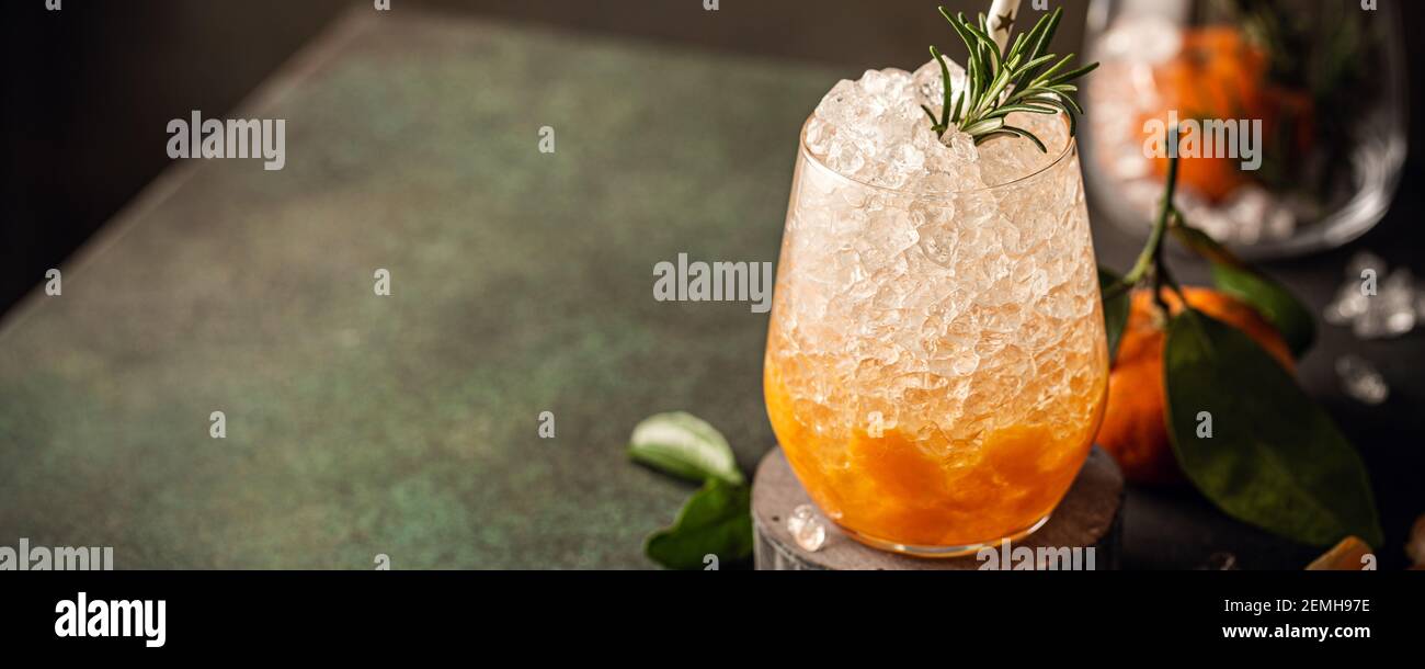 Fresh cocktail with crushed ice, rosemary and tangerines Stock Photo