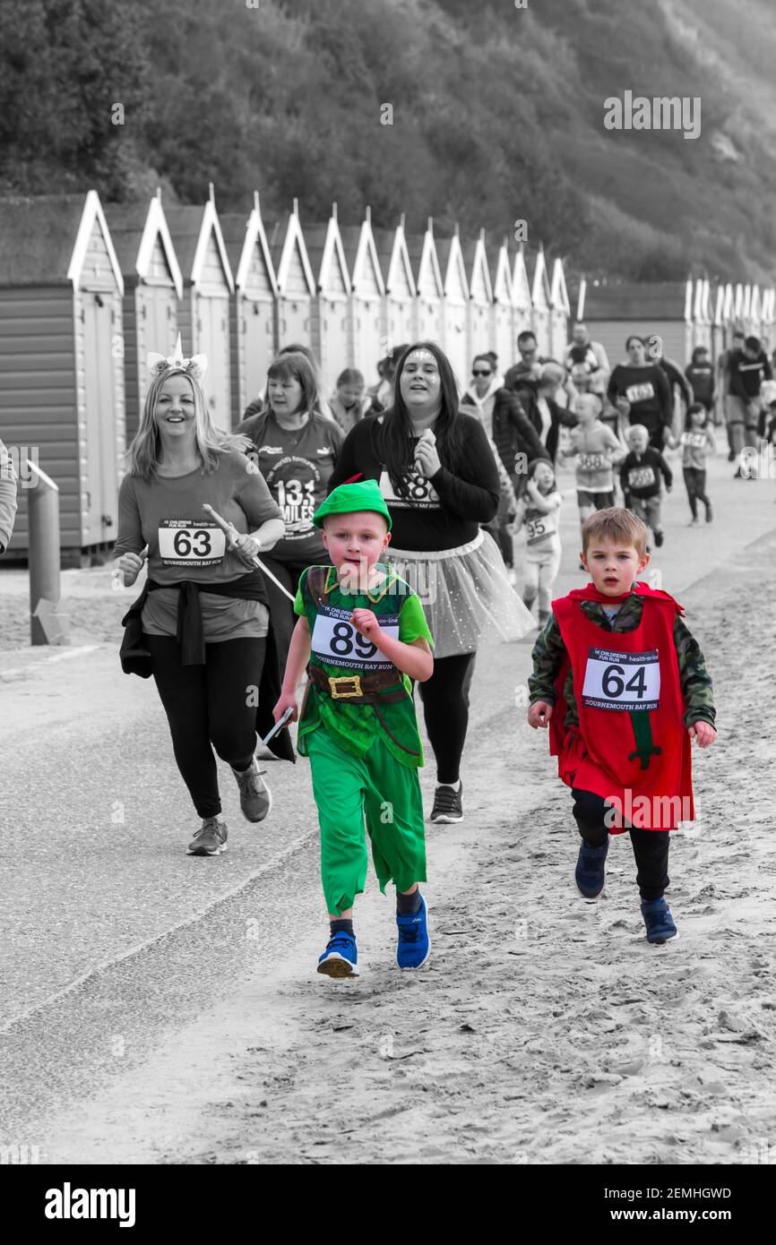 Children and families running in 1k Kids Fun Run in Bournemouth Bay Run at Bournemouth, Dorset UK in April - colour popping Stock Photo