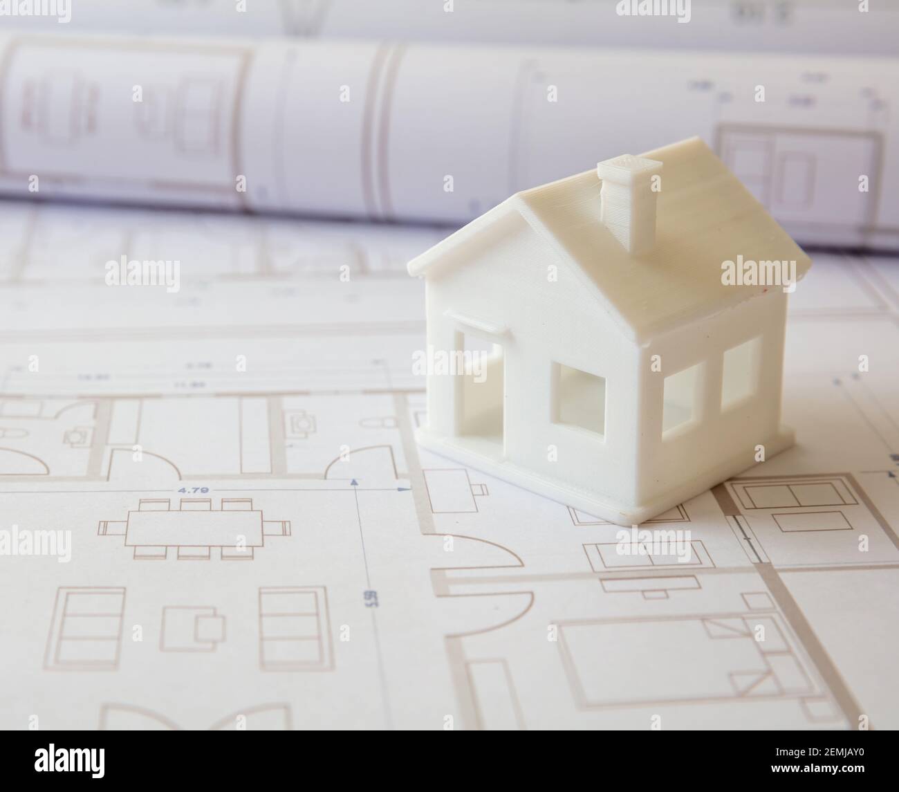 Construction design blueprints concept. Housing project drawings and architectural house model on an office desk. Architect engineer work space Stock Photo