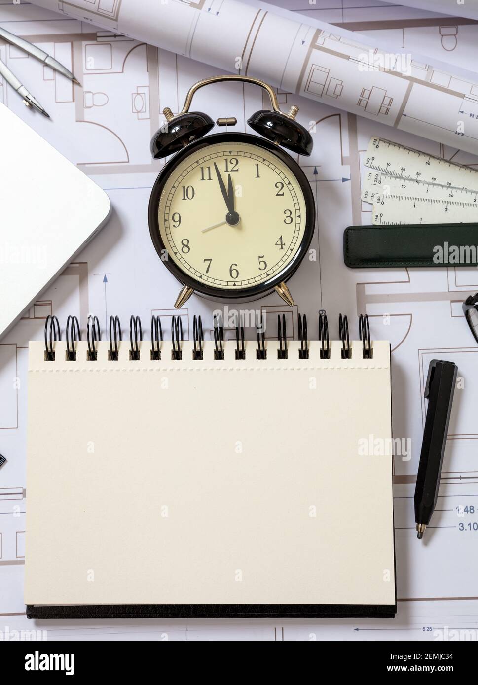 Construction design deadline. Engineer blank notebook and alarm clock ...