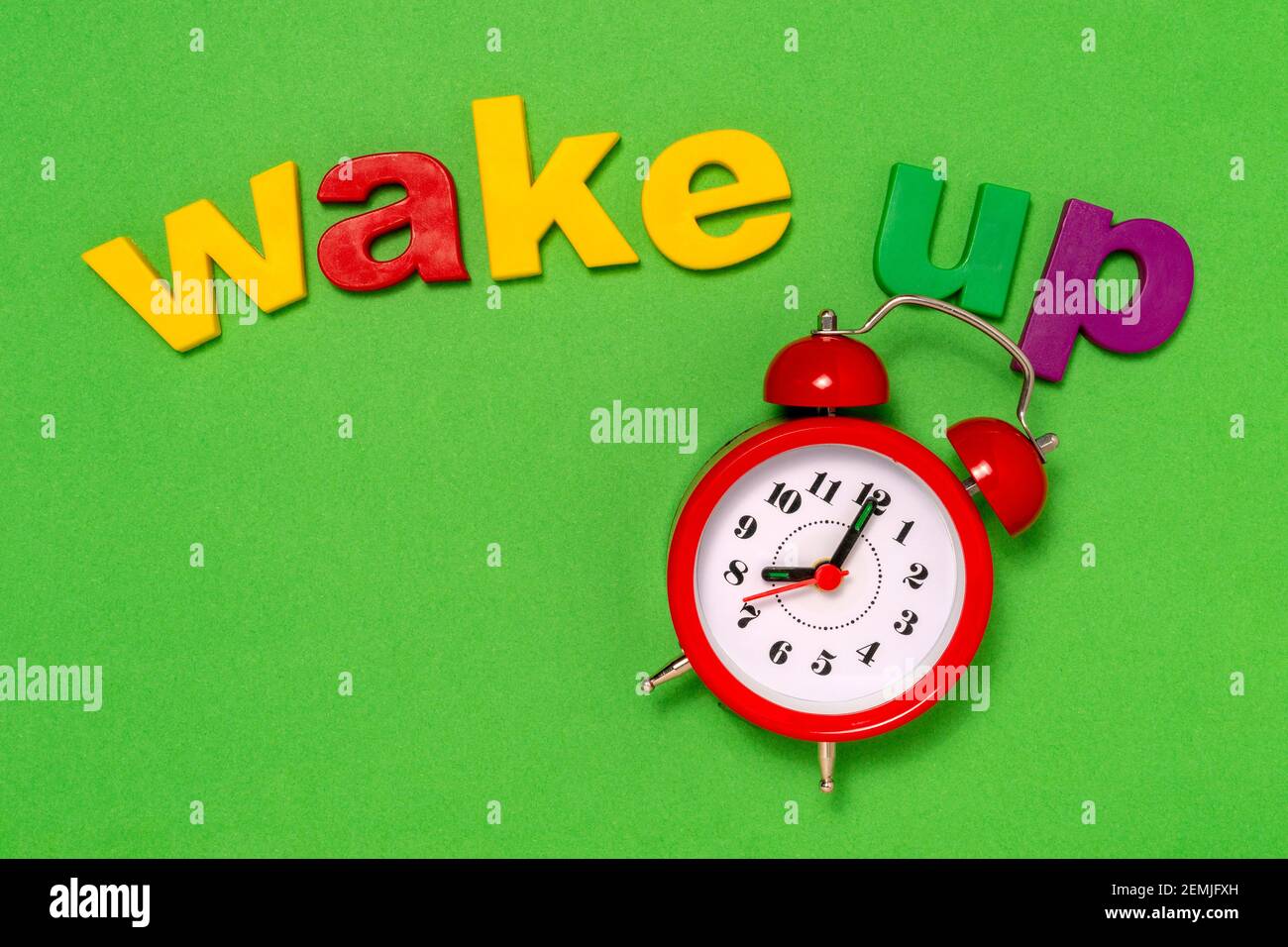 Alarm 8 o' Clock and wake up concept. Alarm clock on the green background with words Wake Up
