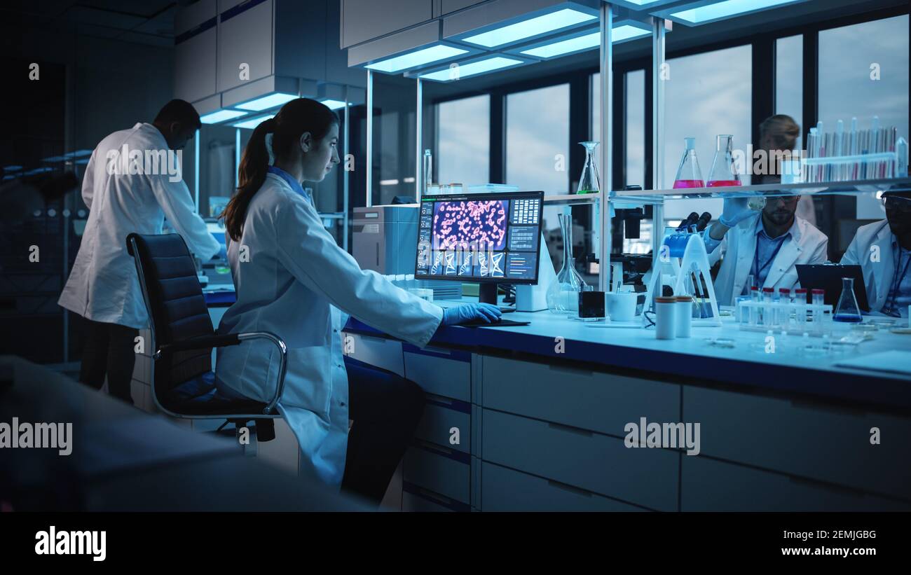 Modern Medical Research Laboratory: Portrait of Female Scientist Working on Computer, Analysing Biochemicals. Advanced Scientific Lab for Medicine Stock Photo