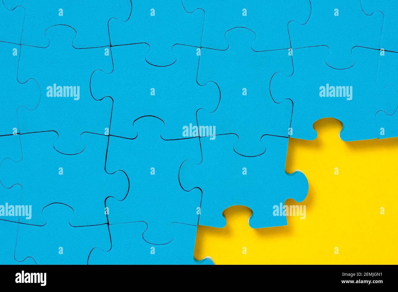 Unfinished blue puzzle at the yellow corner with a copy space Stock