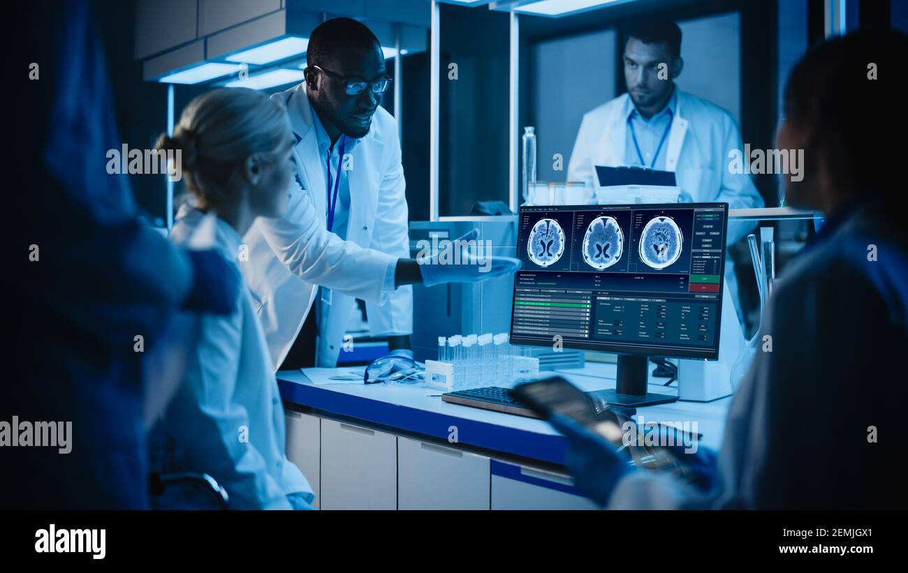 Medical Research Laboratory Meeting: Diverse Team of Scientists Use Computer Showing MRI Brain Scans, Discuss Innovations. Advanced Scientific Lab for Stock Photo