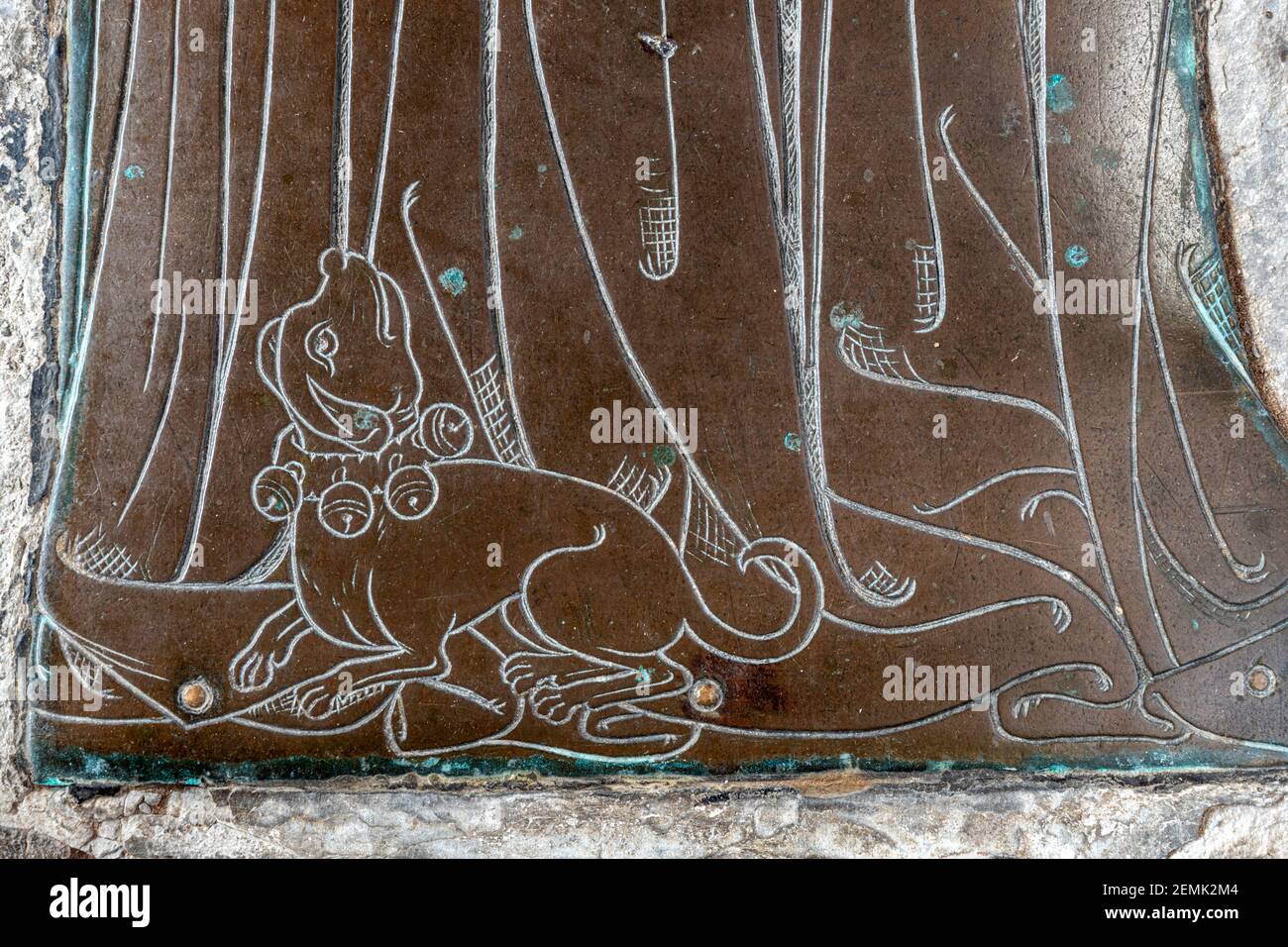 Detail of a memorial brass of an unknown wool merchant (c..1400) lap dog at feet of his wife in the church in the Cotswold town of Northleach, Glos. Stock Photo