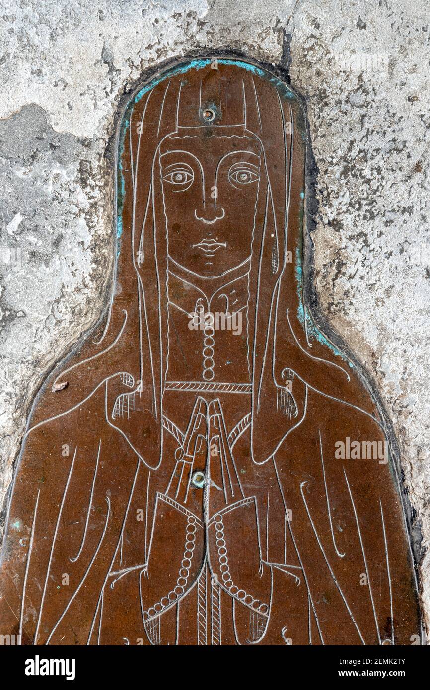 A detail of a memorial brass of the wife of an unknown wool merchant (c..1400) in the church in the Cotswold town of Northleach, Gloucestershire UK Stock Photo
