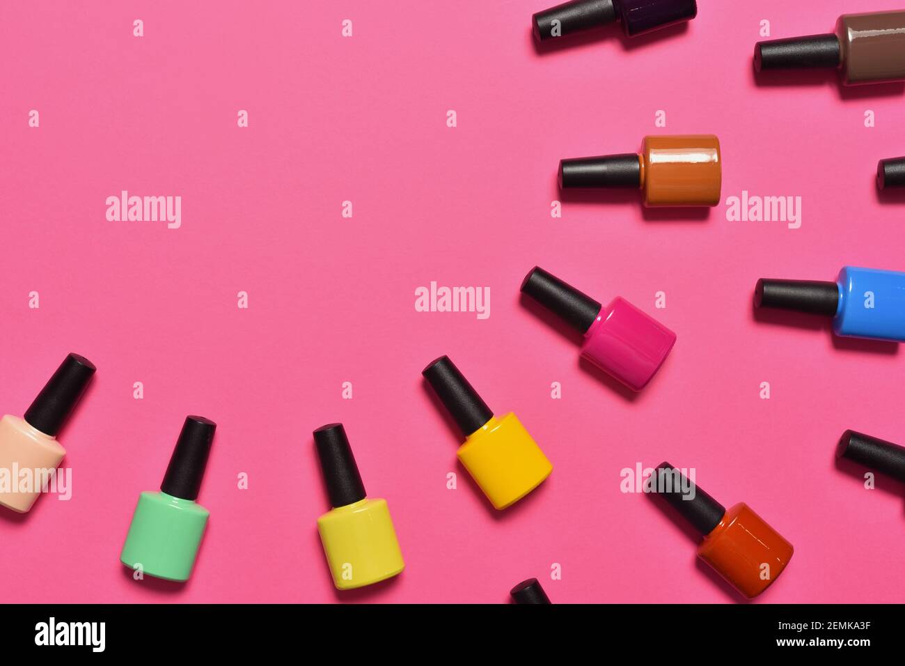 Bottles of nail polish on pink background top view with text space Stock Photo