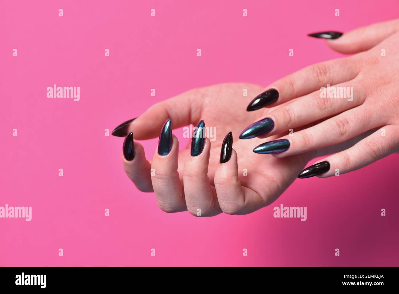 Female hands with new dark manicure on pink background Stock Photo
