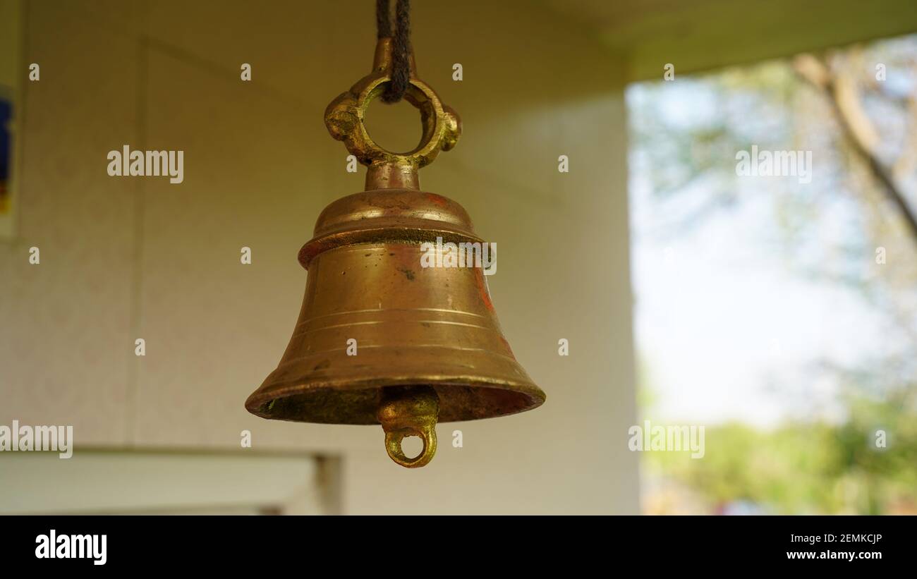 New bronze bell in indian temple isolated on blur background. Close-up of  Hindu temple brass bell hanging in gold color Stock Photo - Alamy