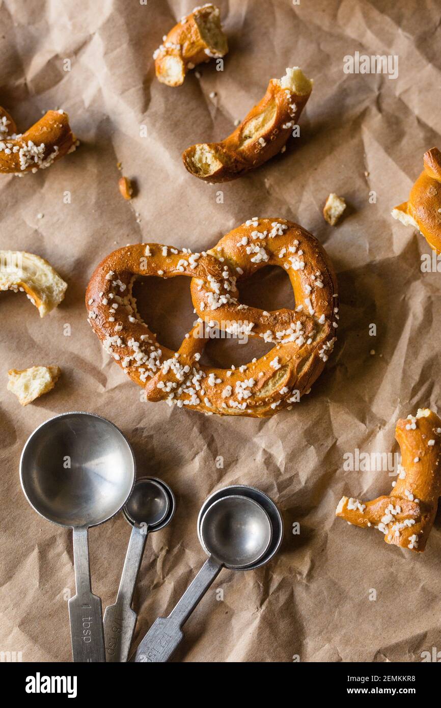Hard Twisted Pretzel with Salt Against Brown Paper Background Stock Photo
