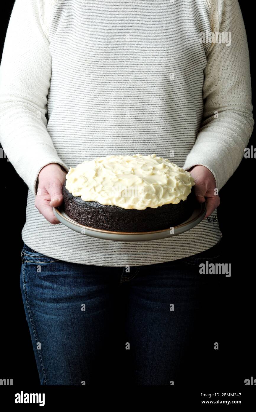 A woman presents a freshly baked Nigella Lawson Chocolate and Guinness cake. Baking has been a popular lock down activity during the COVID outbreak Stock Photo