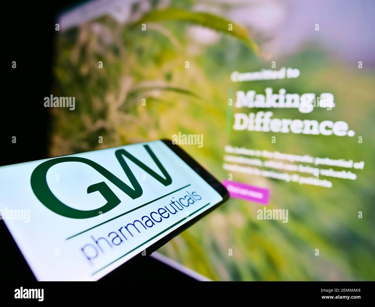Smartphone with business logo of British company GW Pharmaceuticals PLC on screen in front of web page. Focus on center of cellphone display. Stock Photo
