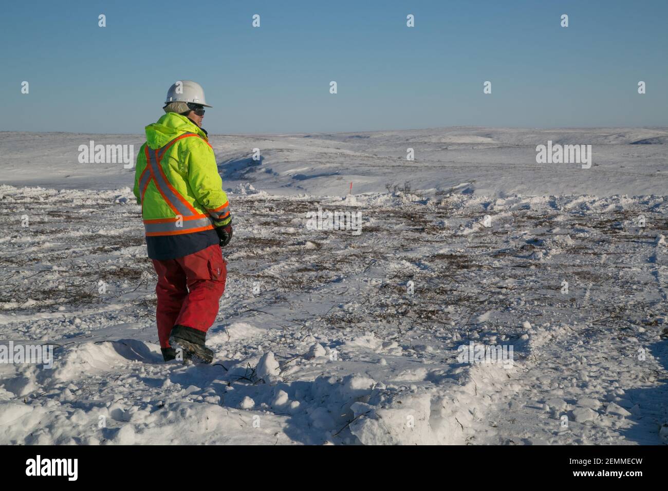 Indigenous woman Safety Officer in uniform at work on the Inuvik-Tuktoyaktuk Highway in winter, Northwest Territories, Canada's Arctic. Stock Photo