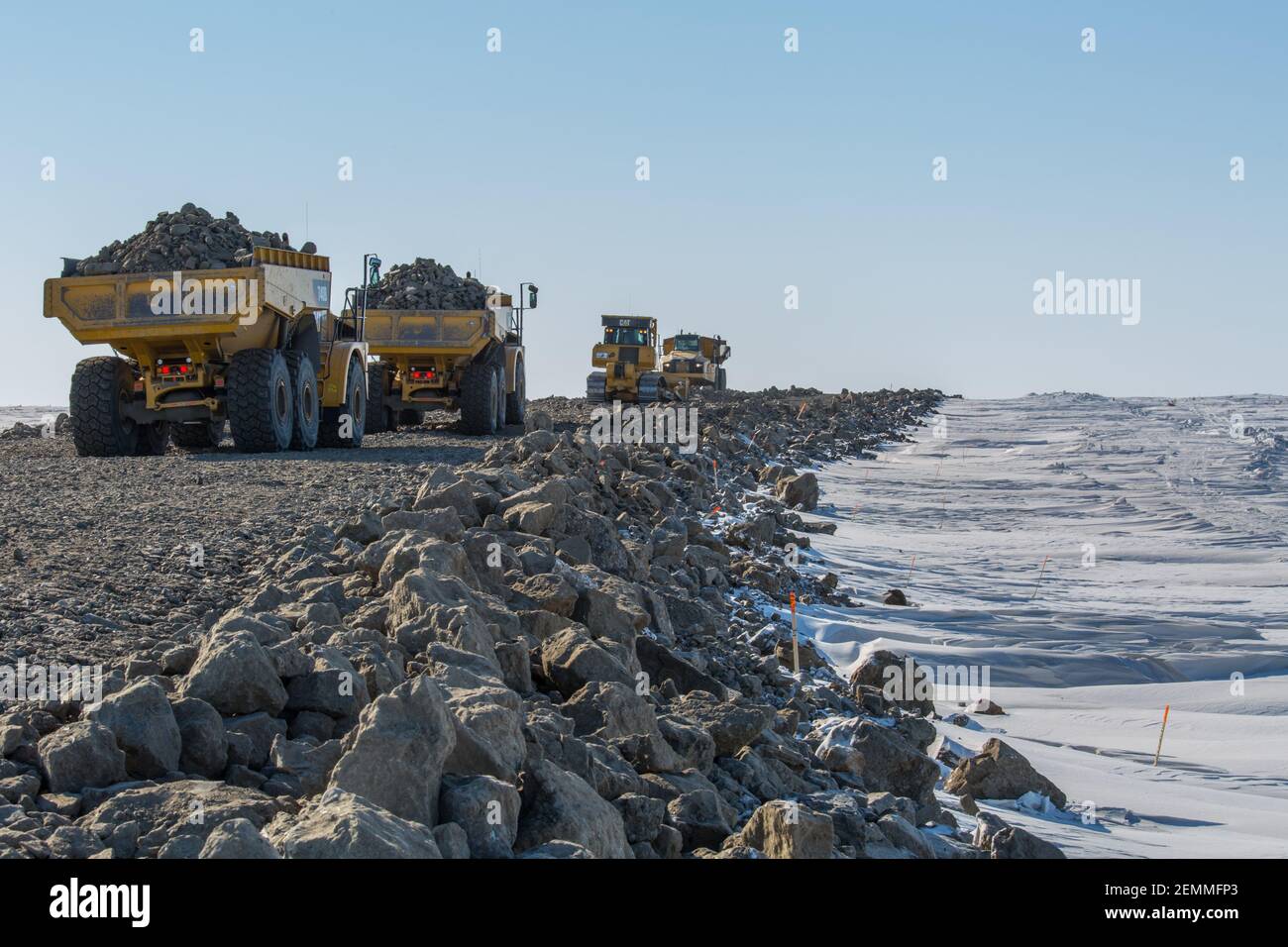 Trucks hauling gravel on the Inuvik-Tuktoyaktuk Highway during winter construction, Northwest Territories, Canada's Arctic (April 2014) Stock Photo