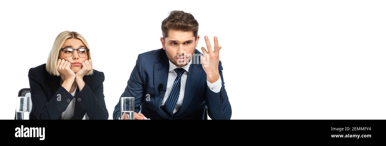 discouraged broadcaster gesturing near upset colleague isolated on white, banner Stock Photo