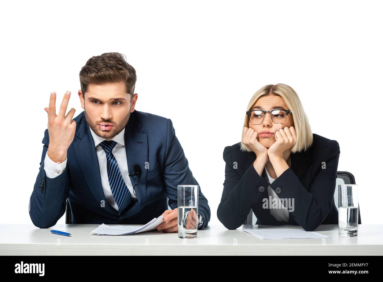 discouraged broadcaster gesturing near upset colleague at workplace isolated on white Stock Photo