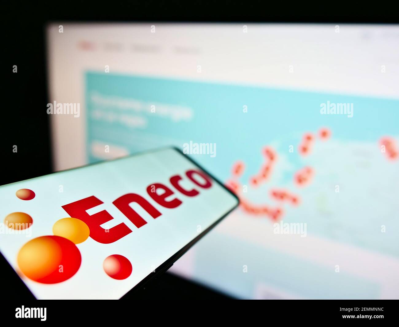 Mobile phone with business logo of Dutch utility company Eneco Groep NV on screen in front of website. Focus on center-left of phone display. Stock Photo