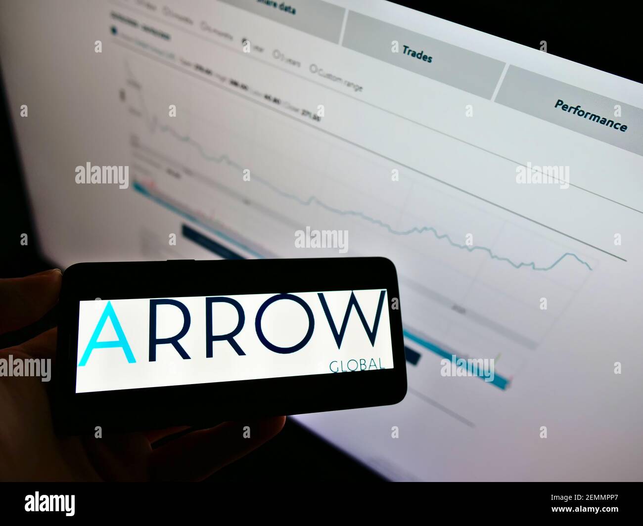 Person Holding Cellphone With Logo Of Investment Company Arrow Global Group Plc On Screen In Front Of Web Page With Chart Focus On Phone Display Stock Photo Alamy