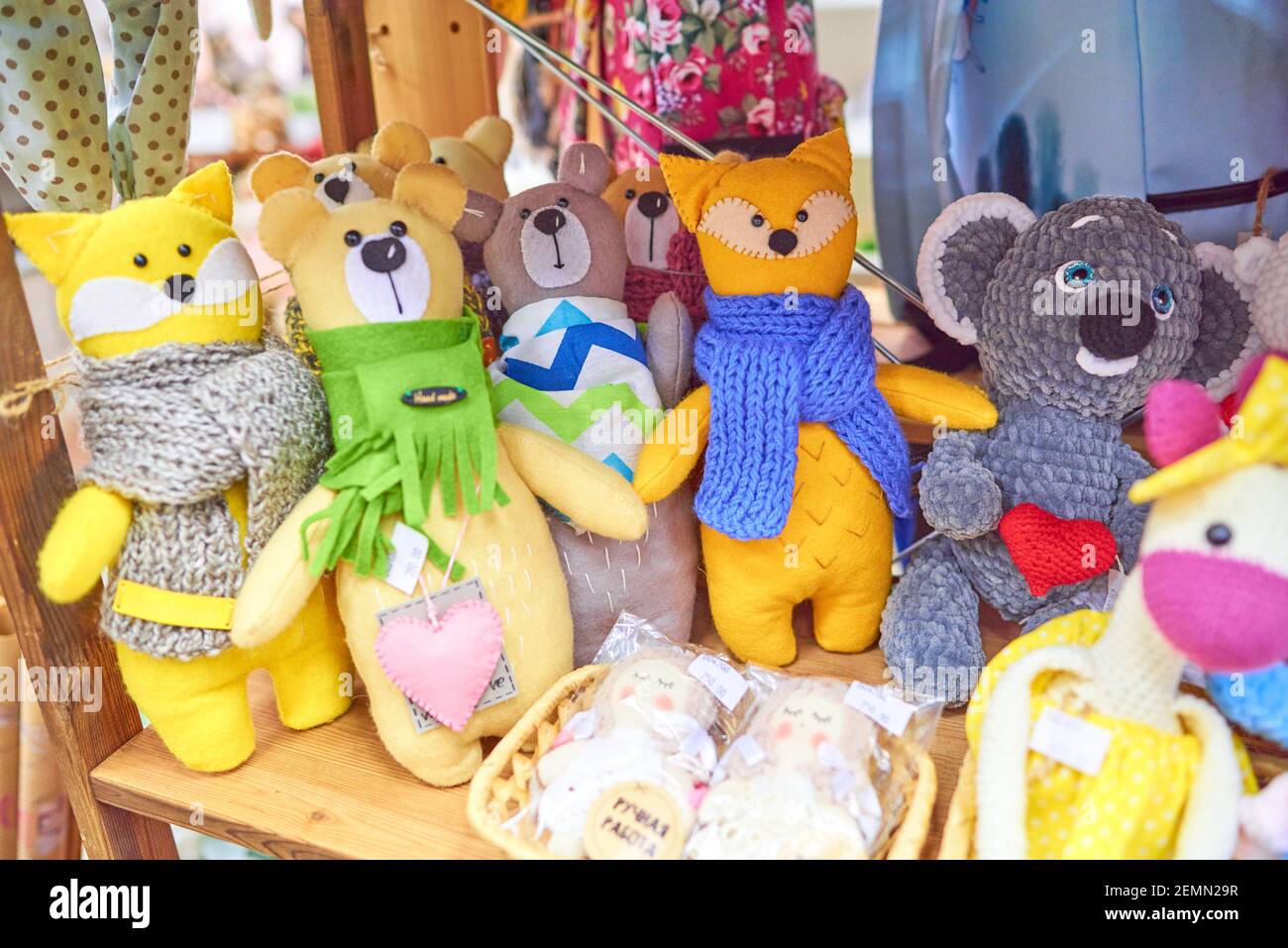 Colored handmade toys cats and teddy bears, yellow, brown, orange, in a green, blue and gray scarf. Russian text: handmade Stock Photo