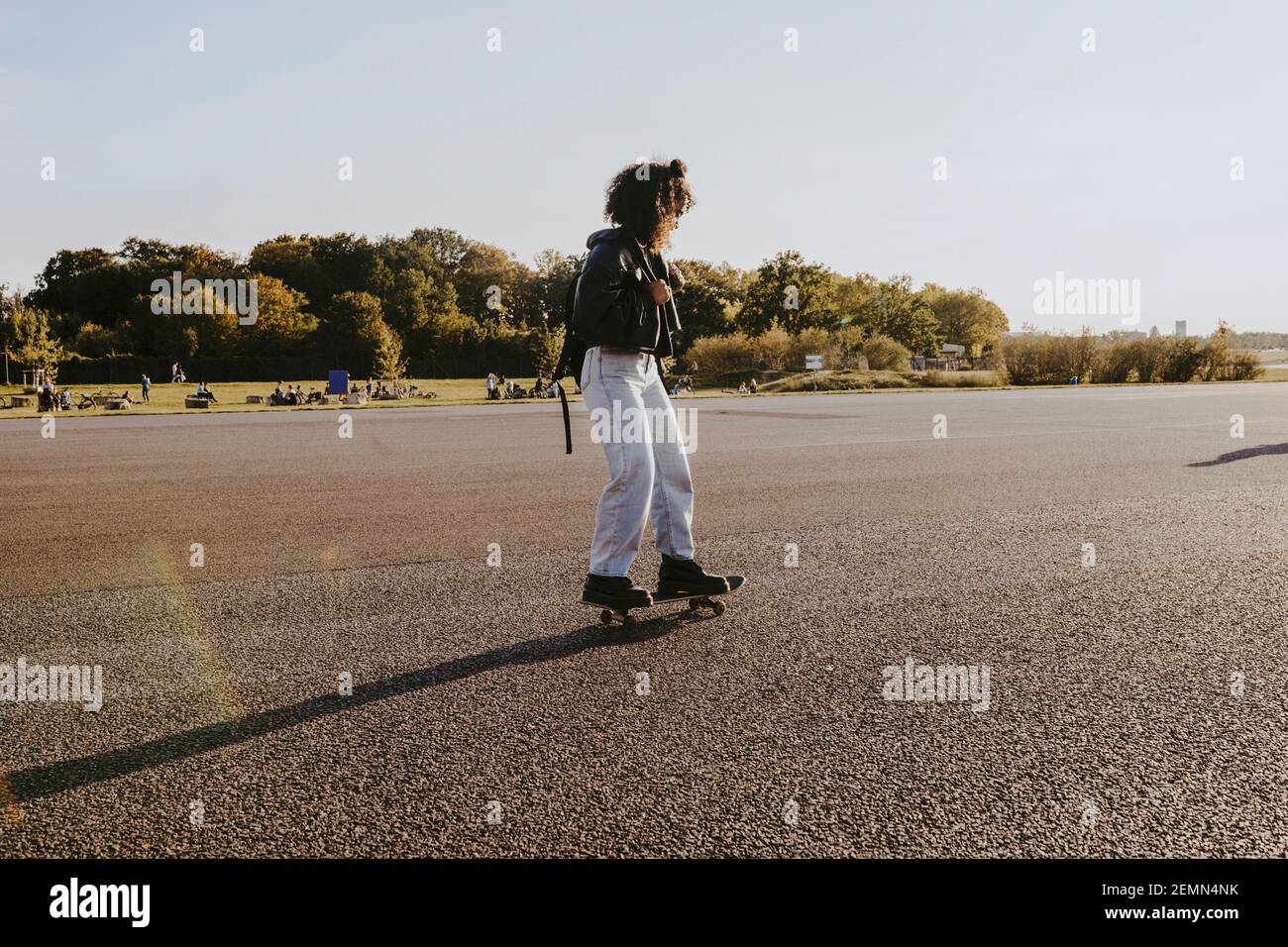Young woman skating in park on sunny day Stock Photo