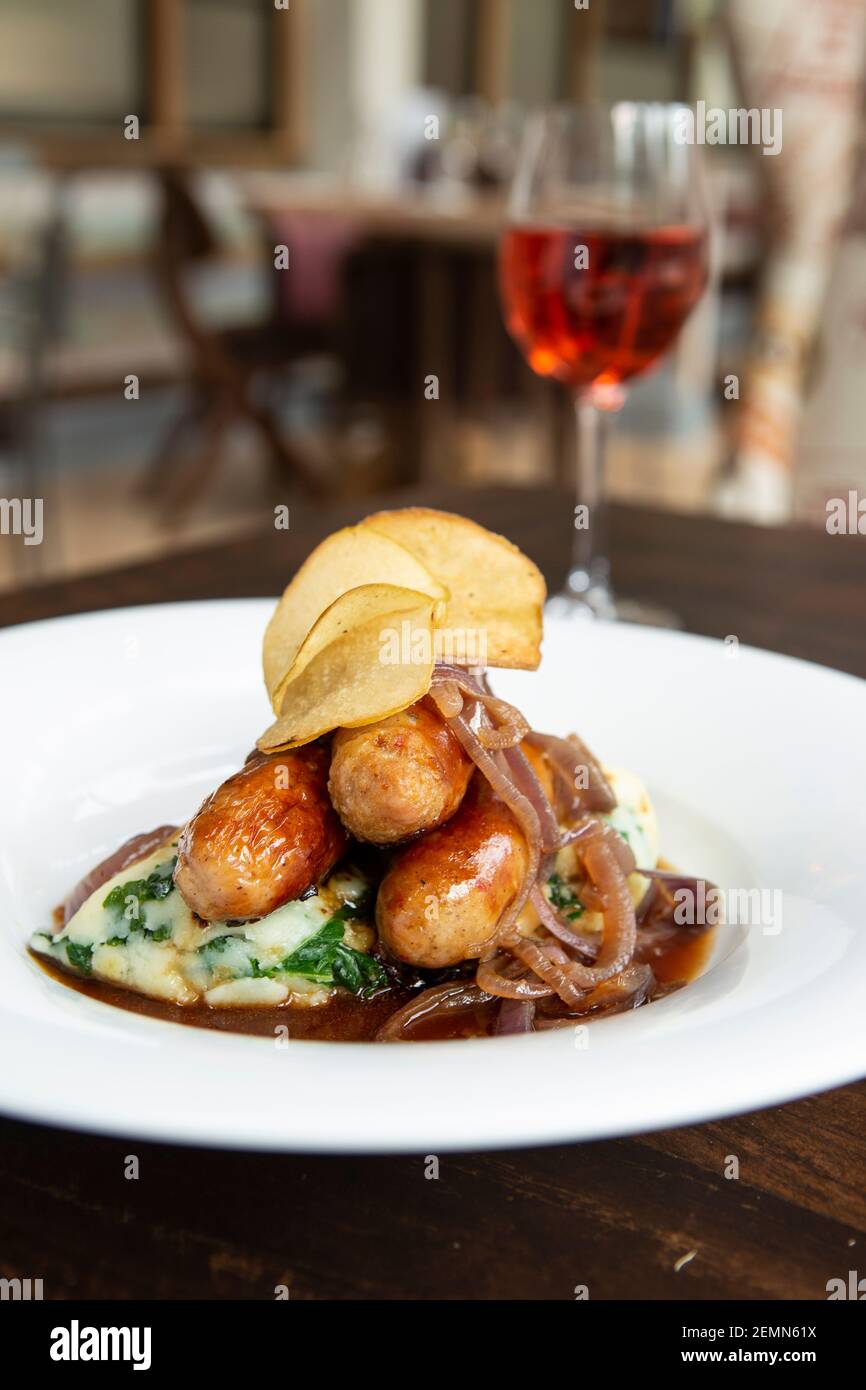 Sausage and mash served with a glass of wine Stock Photo