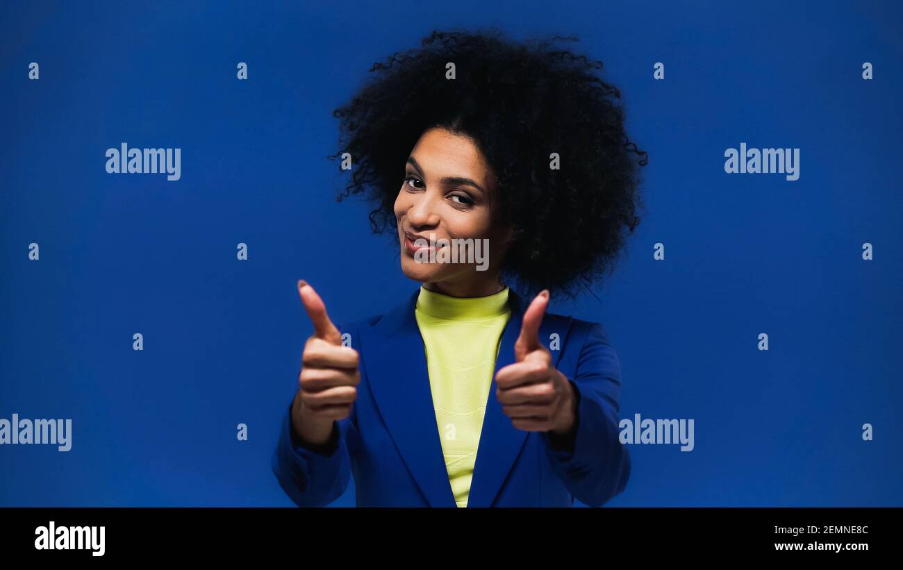 Smiling african american woman showing thumbs up isolated on blue Stock ...