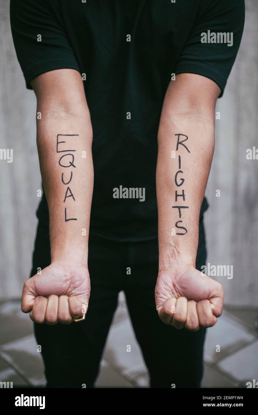 Midsection of male protestor showing equal rights written on hand Stock Photo