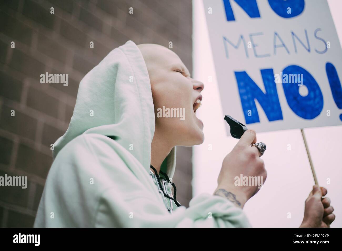 Female activist screaming with signboard during social movement Stock Photo