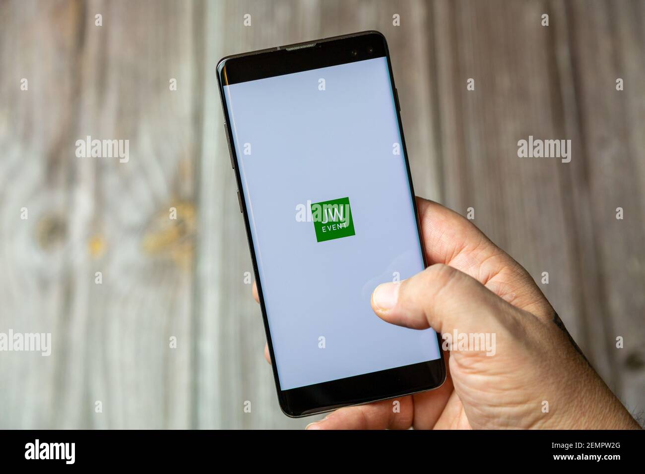 A mobile phone or cell phone being held by a hand with the JW Events