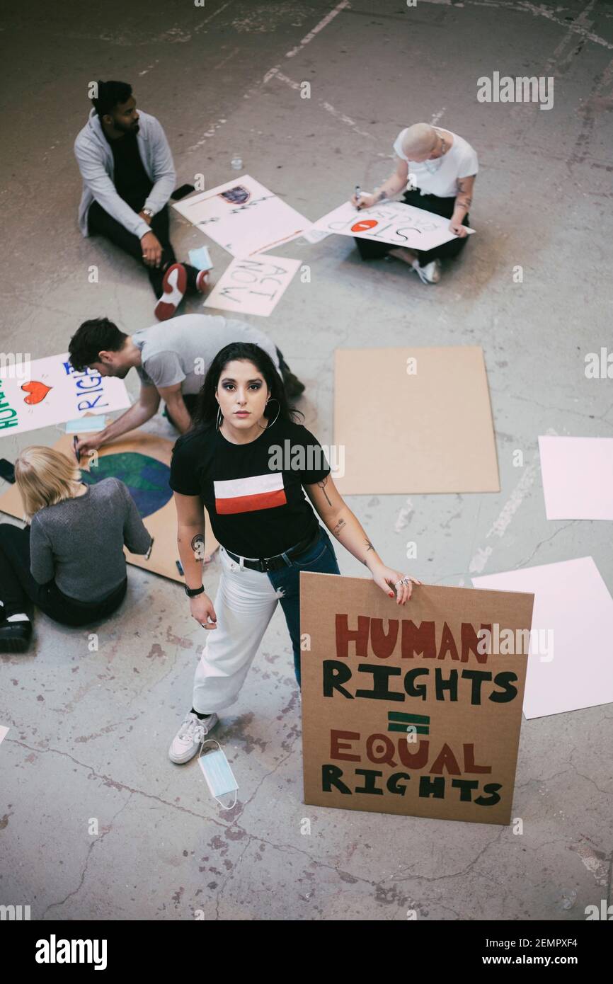 Female activist with equal rights signboard standing in building Stock Photo
